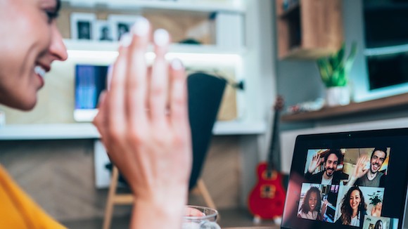 student waving at screen for virtual class