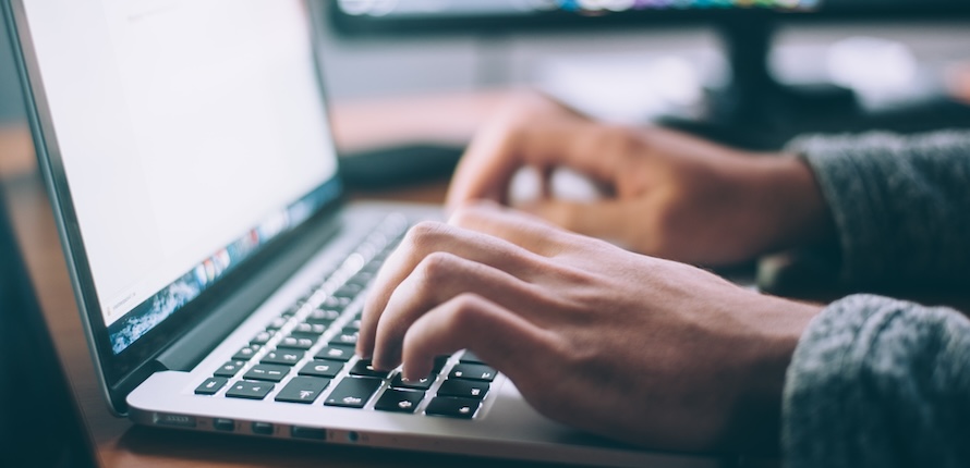 hands typing on a laptop