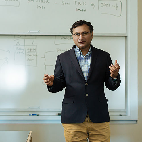 Professor lectures in front of white board