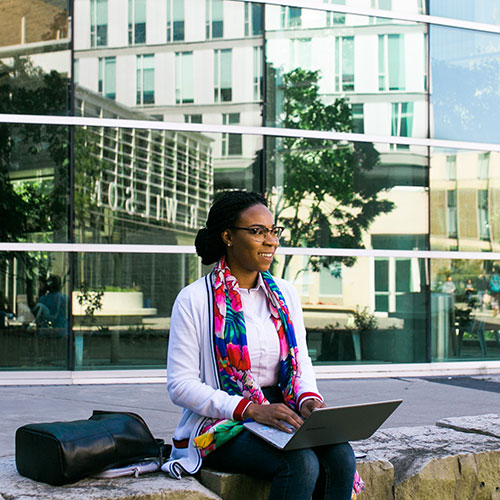 MABE student sits outside building