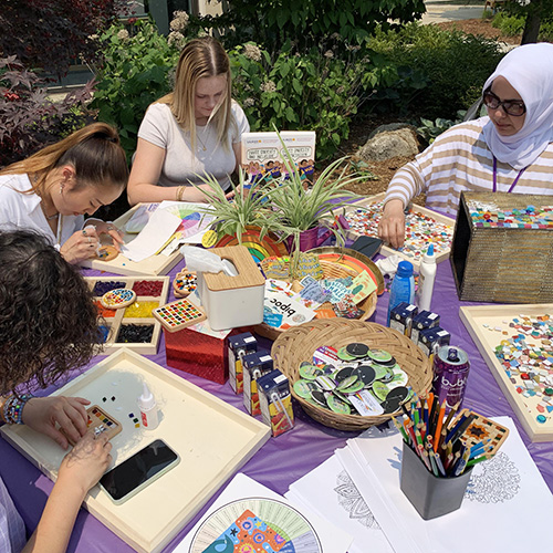 Students sitting at a table working on crafts