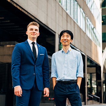 Two students standing in front of office building