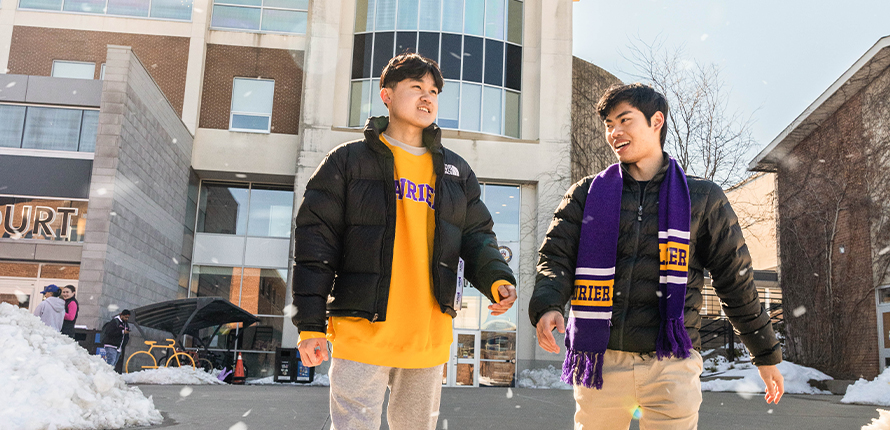 two male students walking on waterloo campus in winter