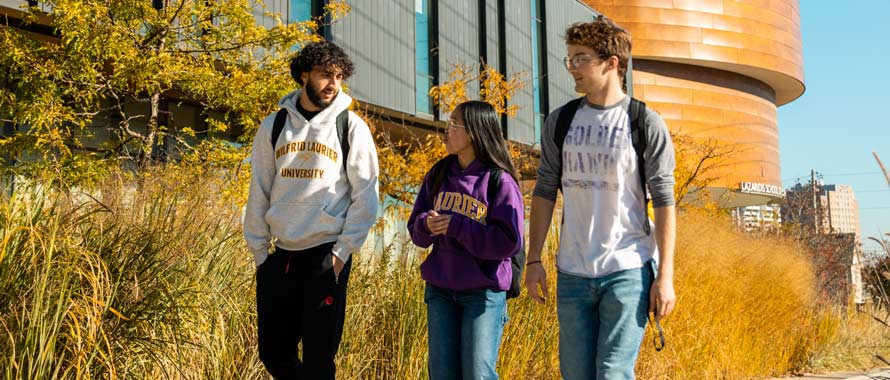 three students students walking outside of lazaridis building